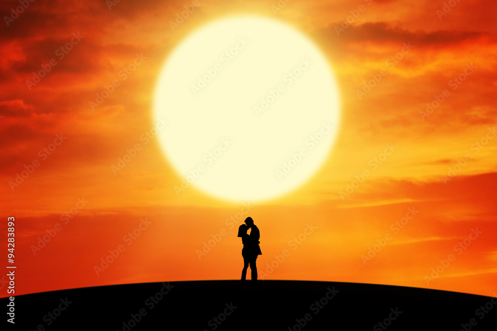 Couple kissing on the hill at sunset time