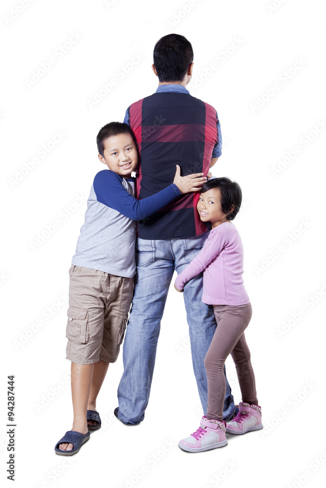 Two children embracing their father in the studio Two children embracing their father in the studio