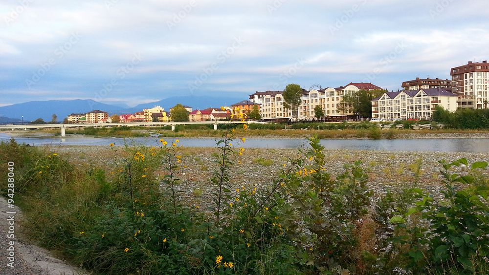 Houses on the embankment of the river, bridge and mountains on the horizon, the resort town Adler