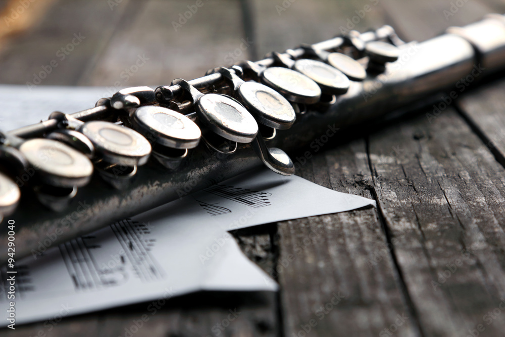 Old silver flute and music notes on rusty table Old silver flute and music notes on rusty table