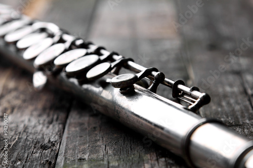 Old silver flute on rusty wooden table