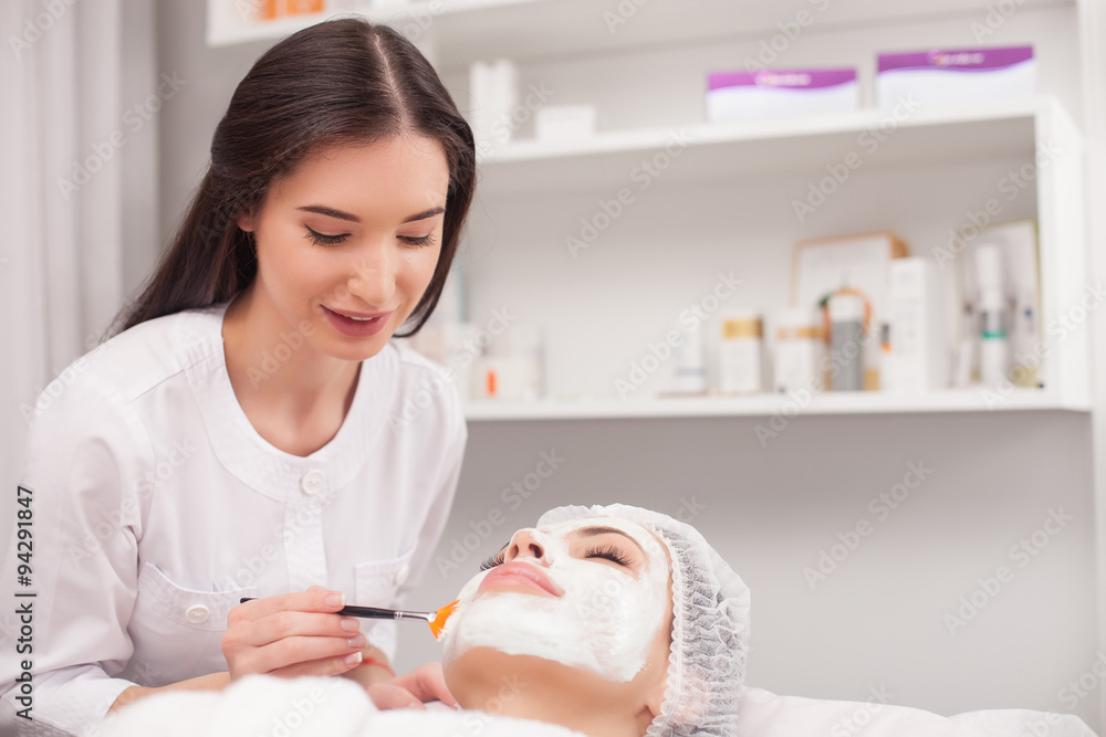 Cheerful expert beautician is serving her customer Cheerful expert beautician is serving her customer