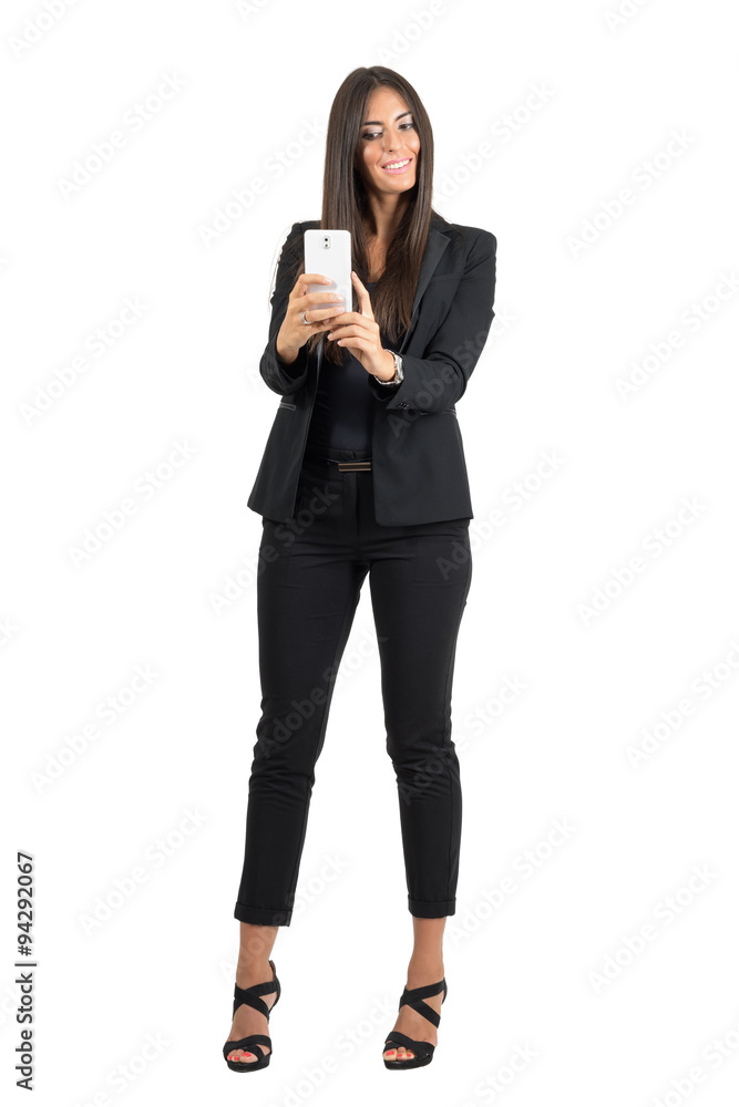 Happy business woman in black suit taking photo with cellphone isolated Happy business woman in black suit taking photo with cellphone isolated