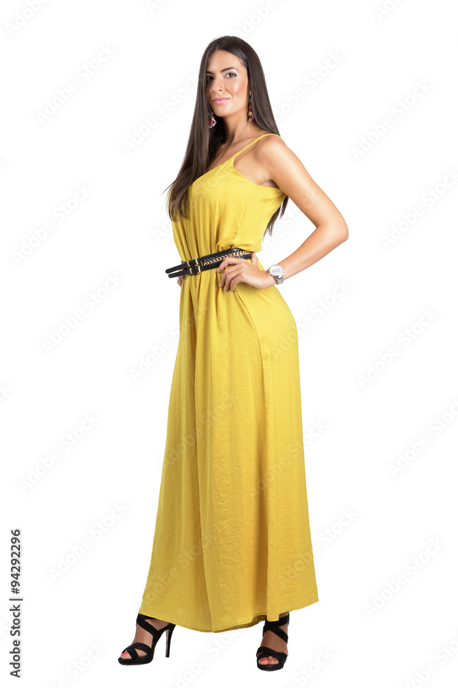 Attractive sensual fashion woman in yellow jumpsuit posing with hand on hip