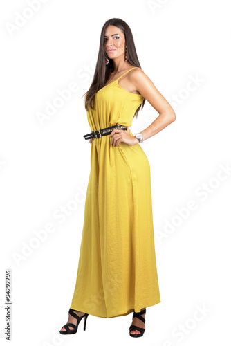 Attractive sensual fashion woman in yellow jumpsuit posing with hand on hip