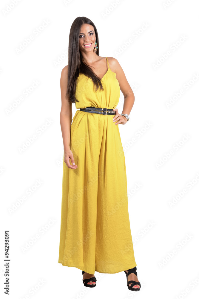 Smiling posing fashion beauty in yellow jumpsuit with hand on her hip isolated