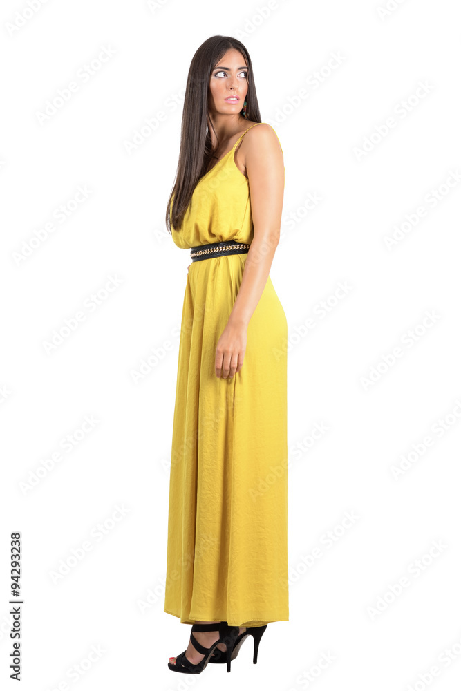 Side view of scared fashion model in evening dress looking behind over her shoulder isolated Side view of scared fashion model in evening dress looking behind over her shoulder isolated