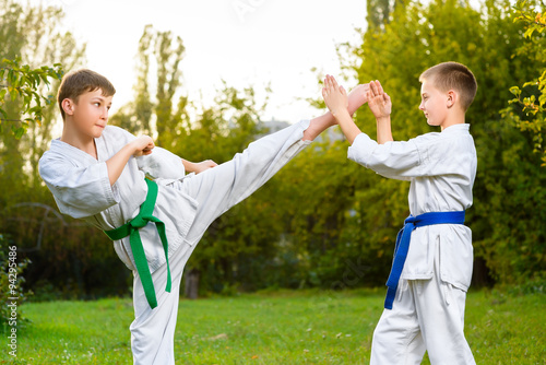 boys in white kimono during training karate exercises at summer photo