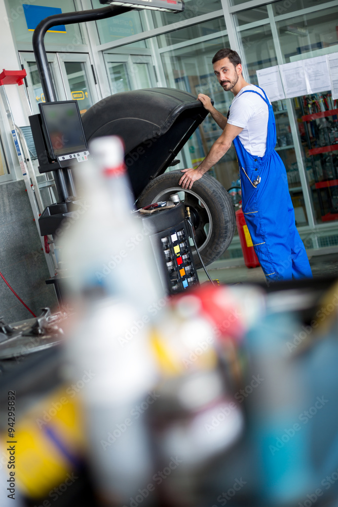 car mechanic working with machine balancer car mechanic working with machine balancer