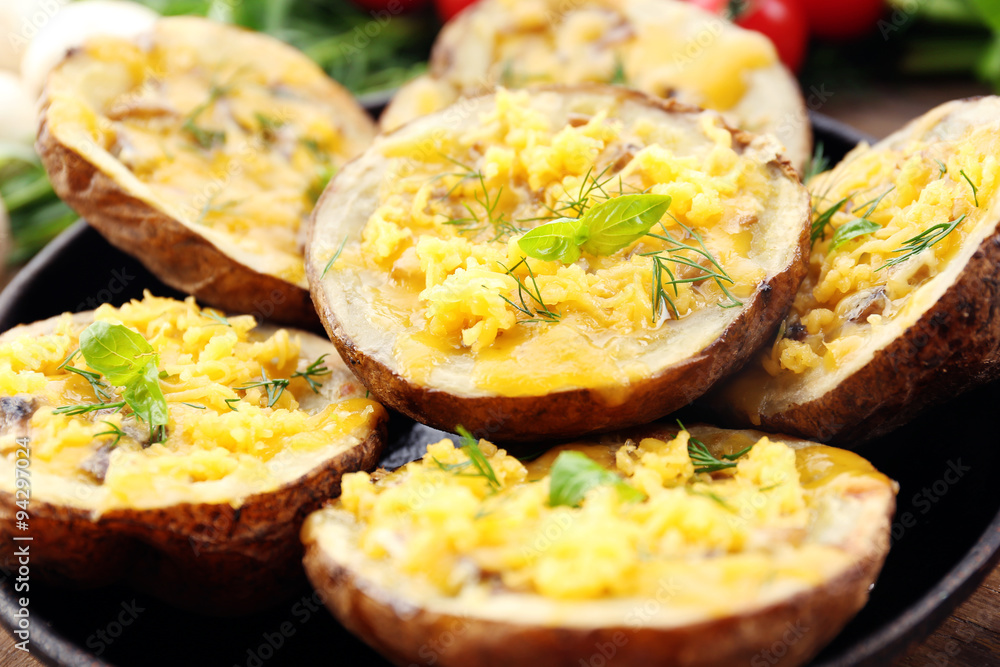 Baked potatoes with cheese and mushrooms on plate close up Baked potatoes with cheese and mushrooms on plate close up