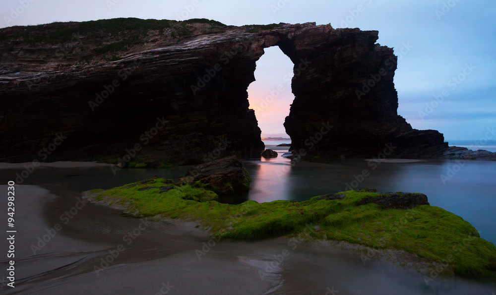 Natural arch at  As Catedrais beach in sunrise-
