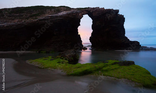 Natural arch at As Catedrais beach in sunrise-