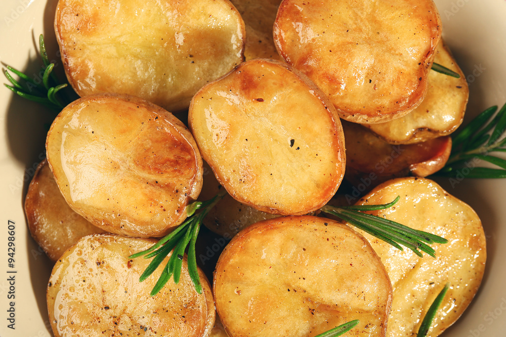 Delicious baked potato with rosemary in bowl close up Delicious baked potato with rosemary in bowl close up
