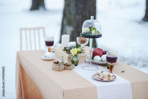 Winter evening outdoor candlelit dinner. Event decoration.  photo