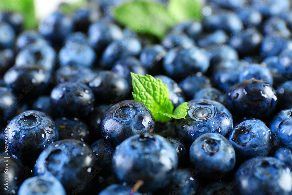 Tasty ripe blueberries with green leaves close up Tasty ripe blueberries with green leaves close up