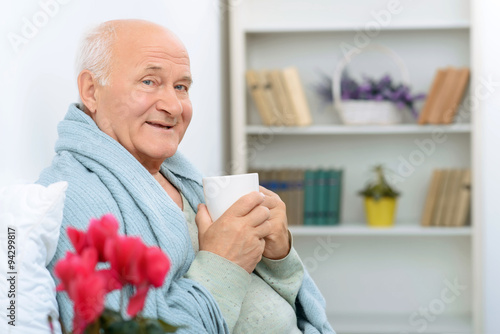 Фотография Elderly gentleman grins happily while resting.