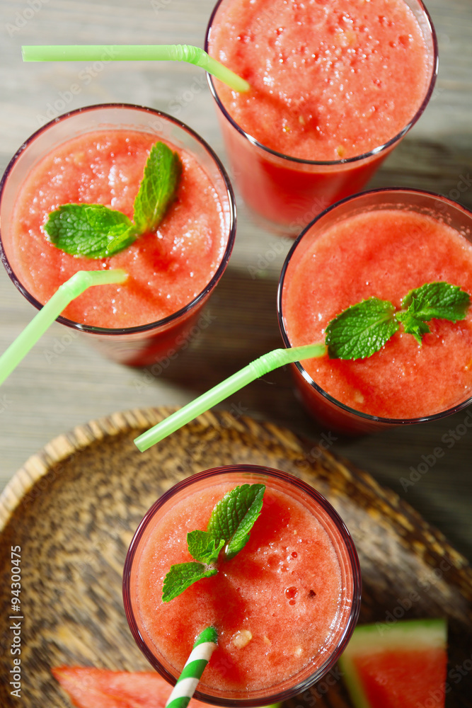 Glasses of watermelon juice on wooden table, top view
