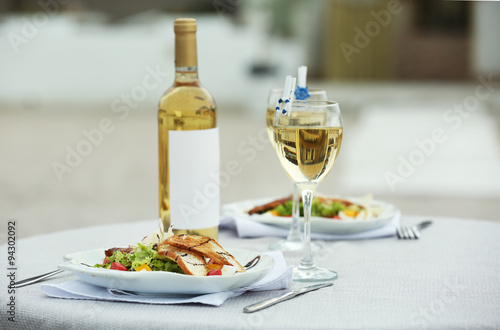 Tasty salad with wine on white served table