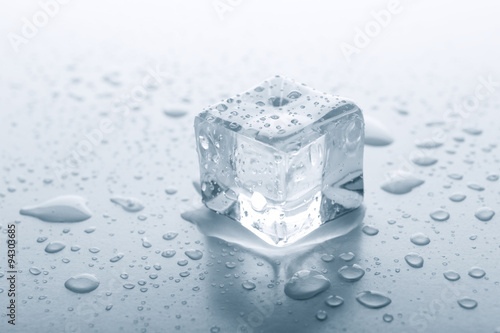 Melting ice cube on grey background