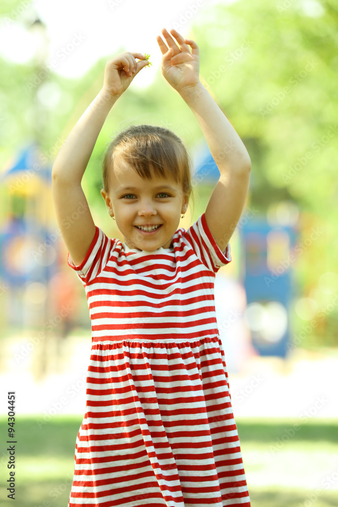 Little happy girl playing in park near the playground Little happy girl playing in park near the playground