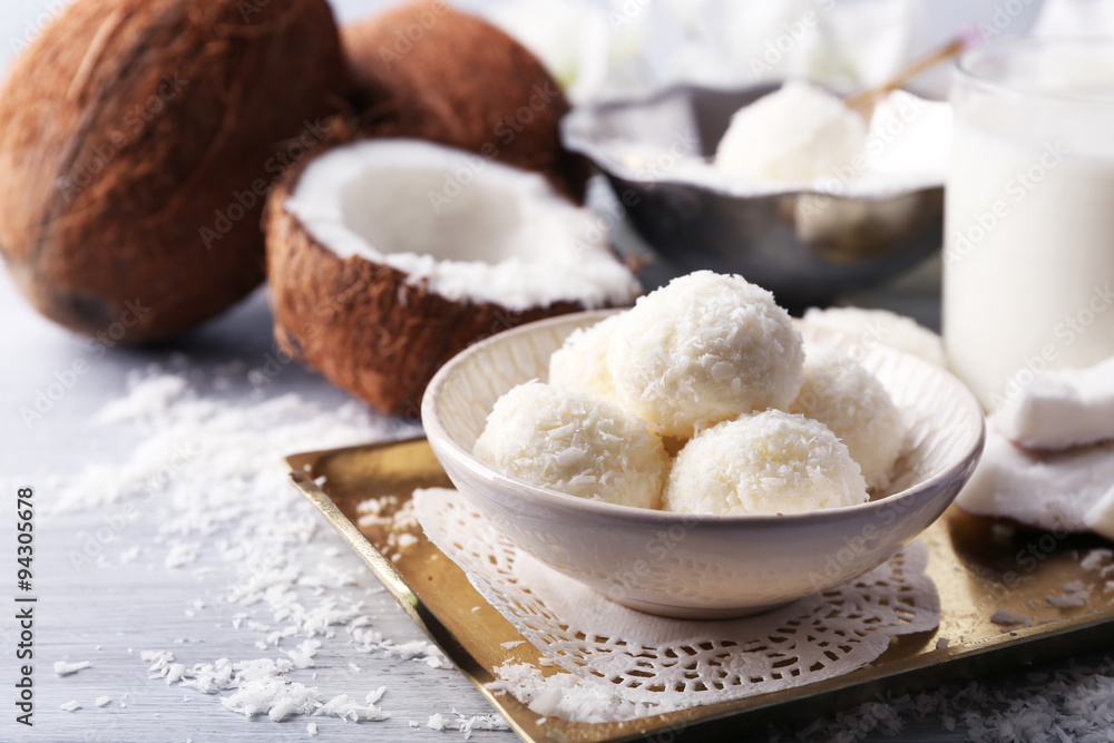 Homemade Candies in coconut flakes and fresh coconut on light background Homemade Candies in coconut flakes and fresh coconut on light background
