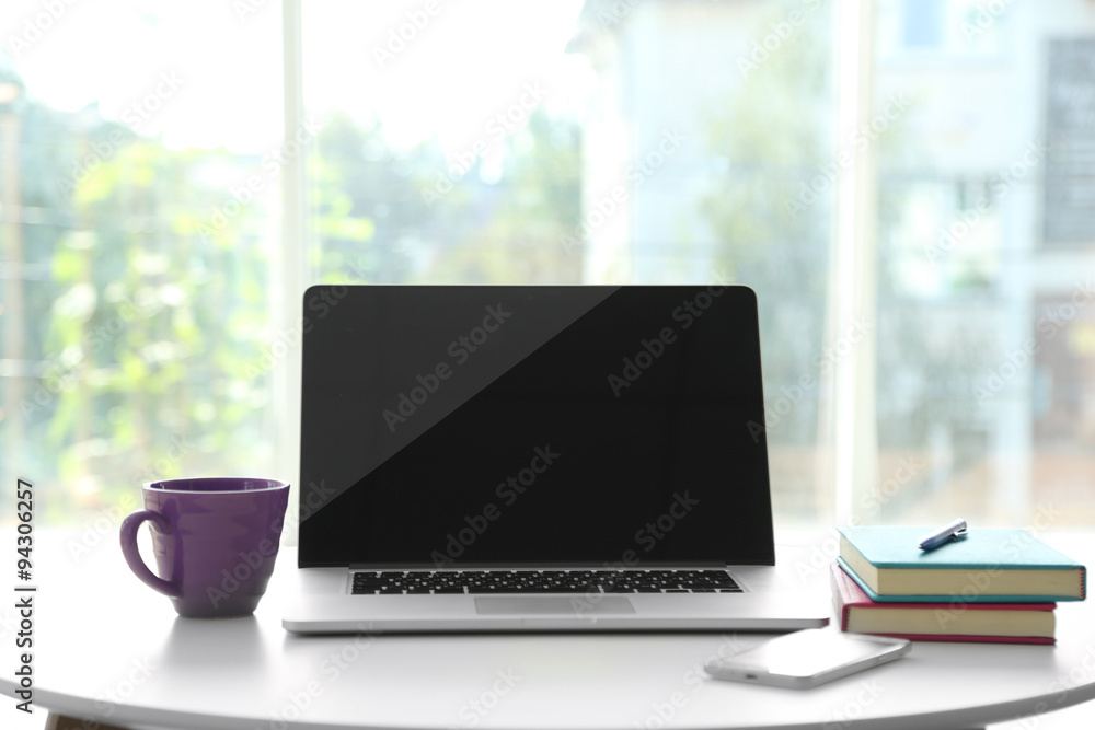 Fototapeta premium Desktop with notebook on window background