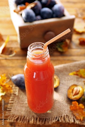 Plum Juice in a glass bottle with fresh fruits