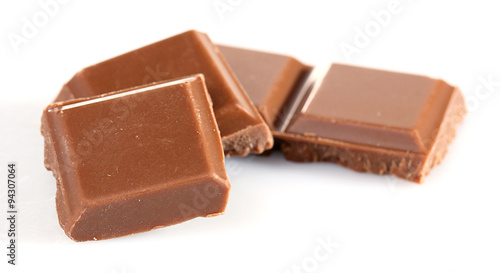 Milk chocolate pieces isolated on white background