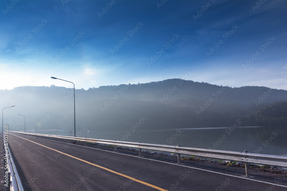 Fototapeta premium Dam and mountains under mist in the morning