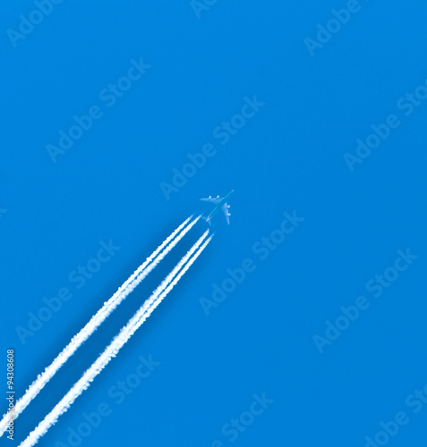 Closeup on airplane contrail against clear blue sky