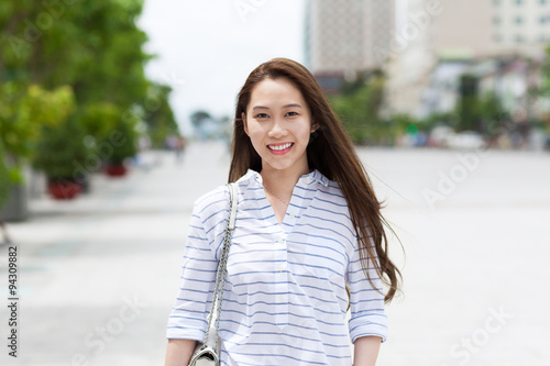 Asian woman face smile walking on city street 