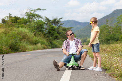 Father and daughter playing on the road.