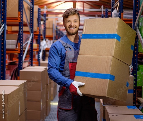 Cuadro en lienzo Porter carrying boxes in a warehouse