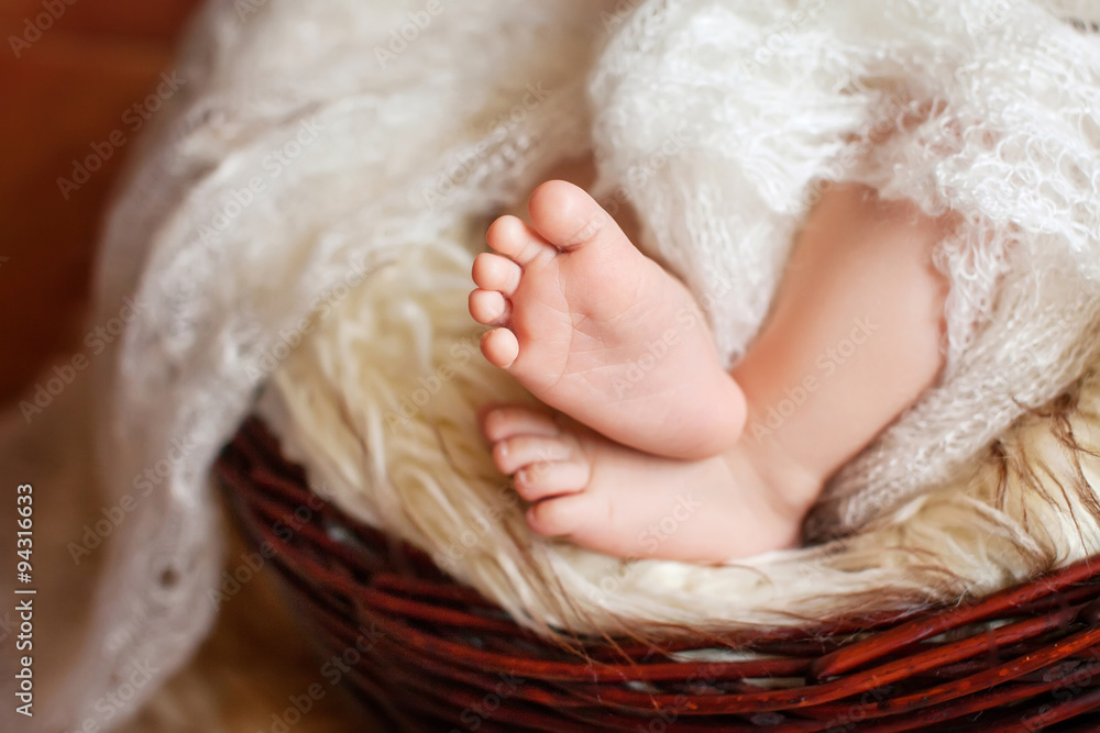 Close up picture of new born baby feet in knitted plaid Close up picture of new born baby feet in knitted plaid