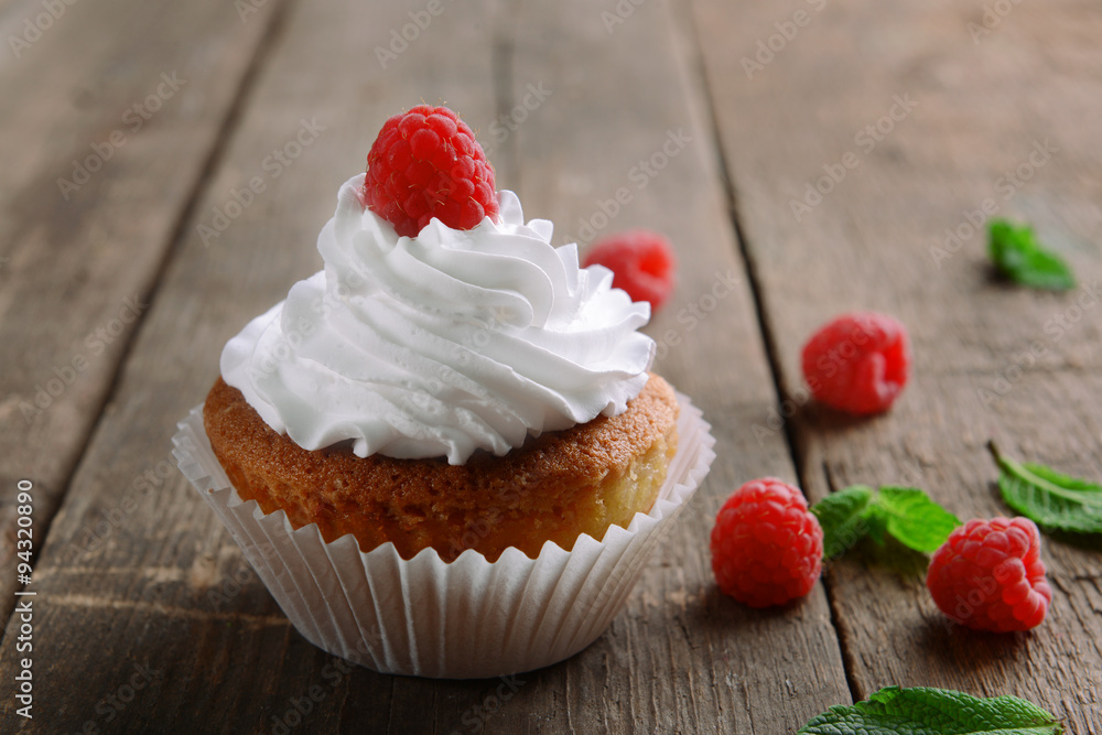 Delicious cupcake with berries and fresh mint on wooden table close up Delicious cupcake with berries and fresh mint on wooden table close up