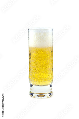 High transparent glass full of cold beer isolated on white closeup. Vertical view