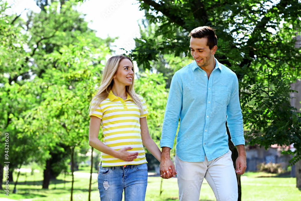 Young pregnant woman with husband walking in park Young pregnant woman with husband walking in park