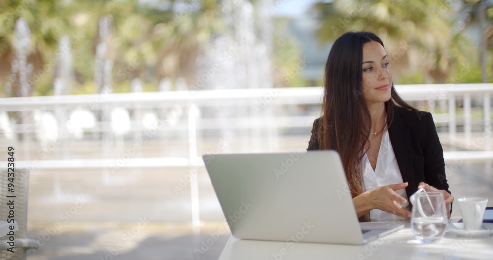 Attractive woman working from an open-air patio Attractive woman working from an open-air patio