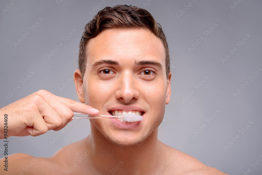 Handsome man cleaning teeth 