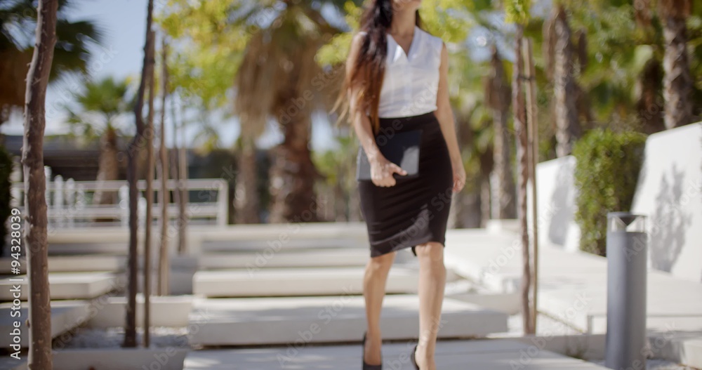 Elegant young woman walking through a park Elegant young woman walking through a park