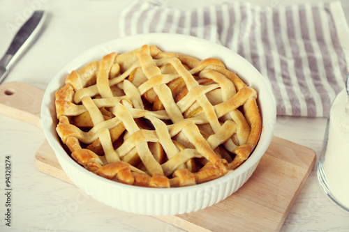 Homemade apple pie on wooden table, on light background