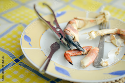 Yellow dinner plate with tasty lobster claw and cracker tool photo