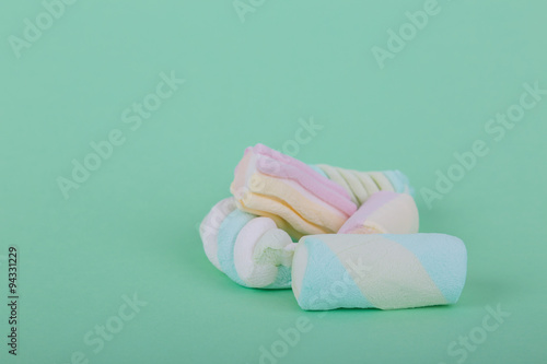 marshmallow candies of different colors in the glass on the background of turquoise. top view. entertainment for children in celebration.