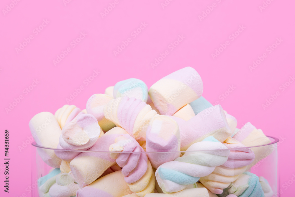 marshmallow candies of different colors in the glass on the background of pink. top view. entertainment for children in celebration.