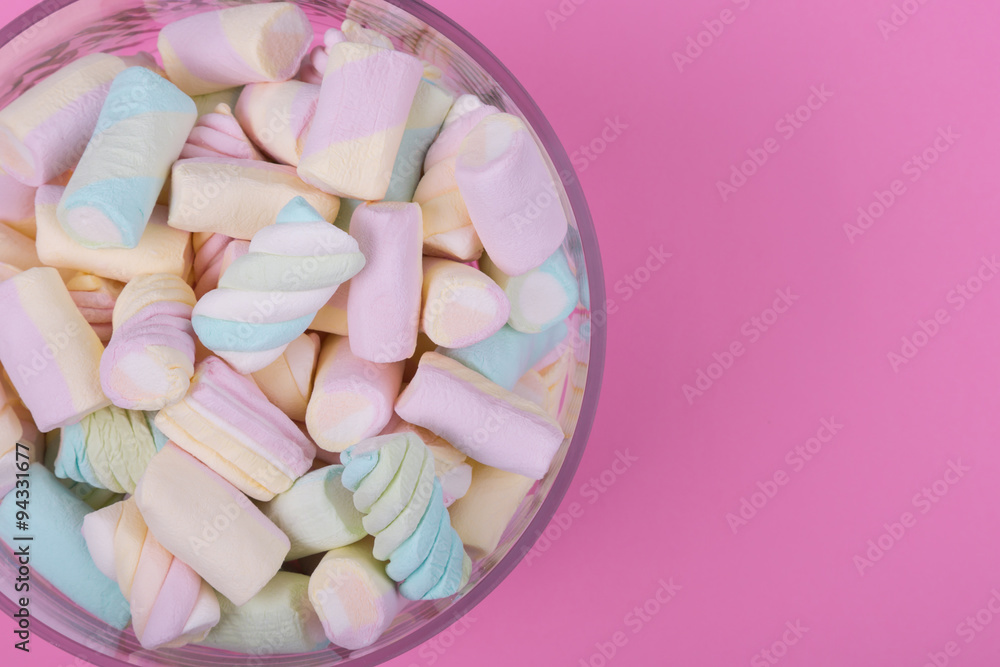 marshmallow candies of different colors in the glass on the background of pink. top view. entertainment for children in celebration. marshmallow candies of different colors in the glass on the background of pink. top view. entertainment for children in celebration.