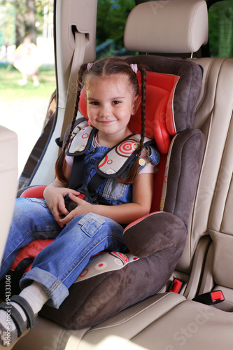Cute little girl sitting in...