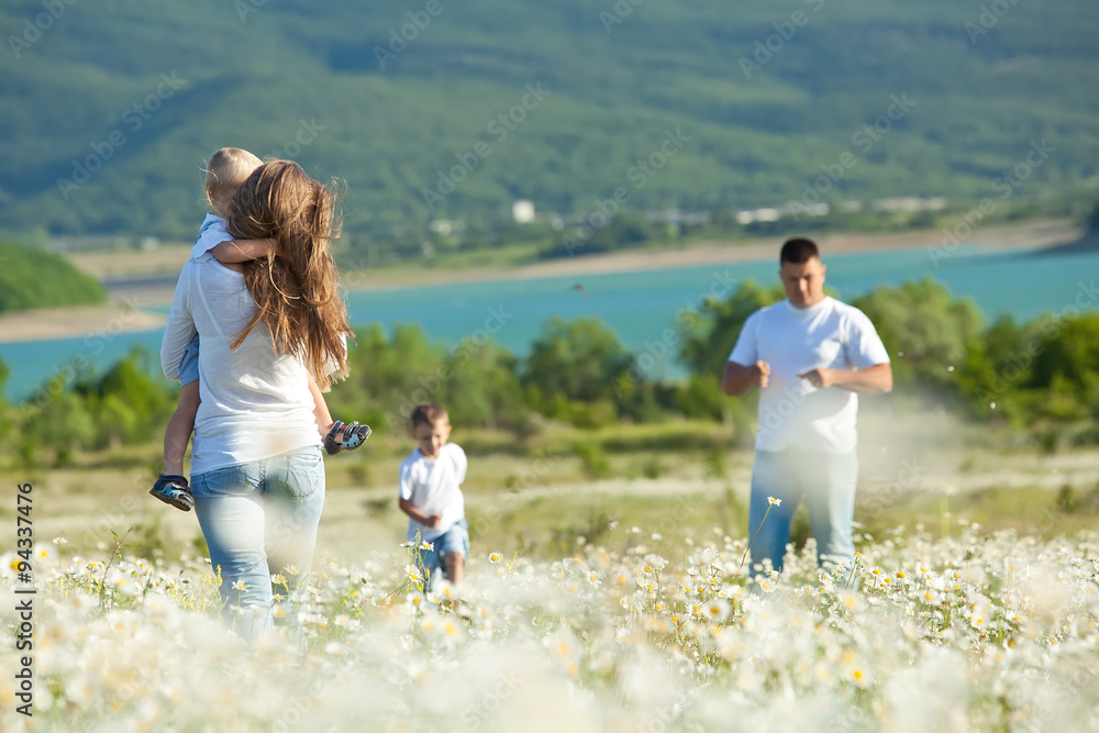Happy family are walking in camomile field Happy family are walking in camomile field