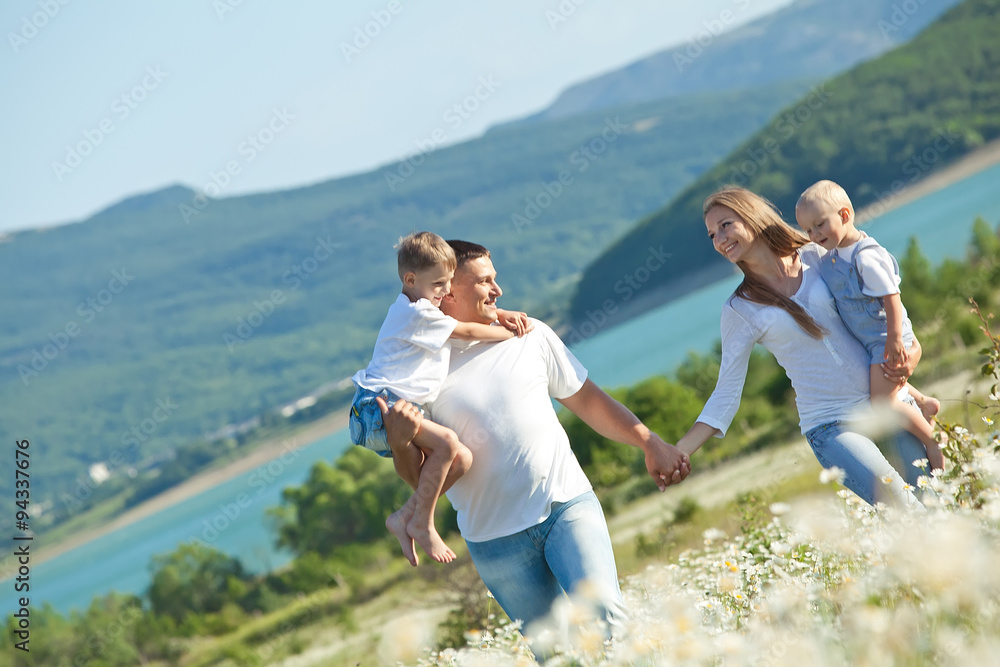 Happy family are walking in camomile field Happy family are walking in camomile field