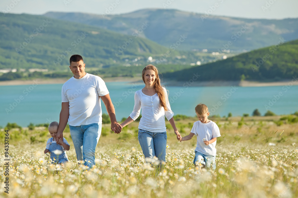 Happy family are walking in camomile field Happy family are walking in camomile field