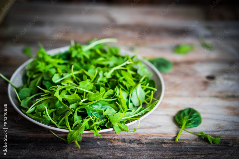 Fresh arugula and spinach salad on rustic background Fresh arugula and spinach salad on rustic background
